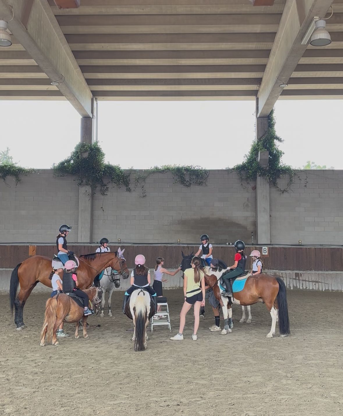 Bambini che partecipano a un campo estivo di equitazione all’aria aperta con cavalli e natura